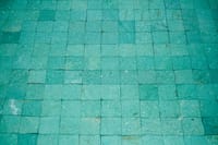 Close-up of an aqua blue textured tile mosaic, ideal for backgrounds or design elements.
