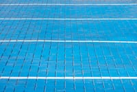 Blue bricked surface with white line patterns creating a geometric abstract design.