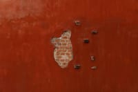 Close-up of a terracotta colored brick wall with cracking and peeling in Escazu, Costa Rica.